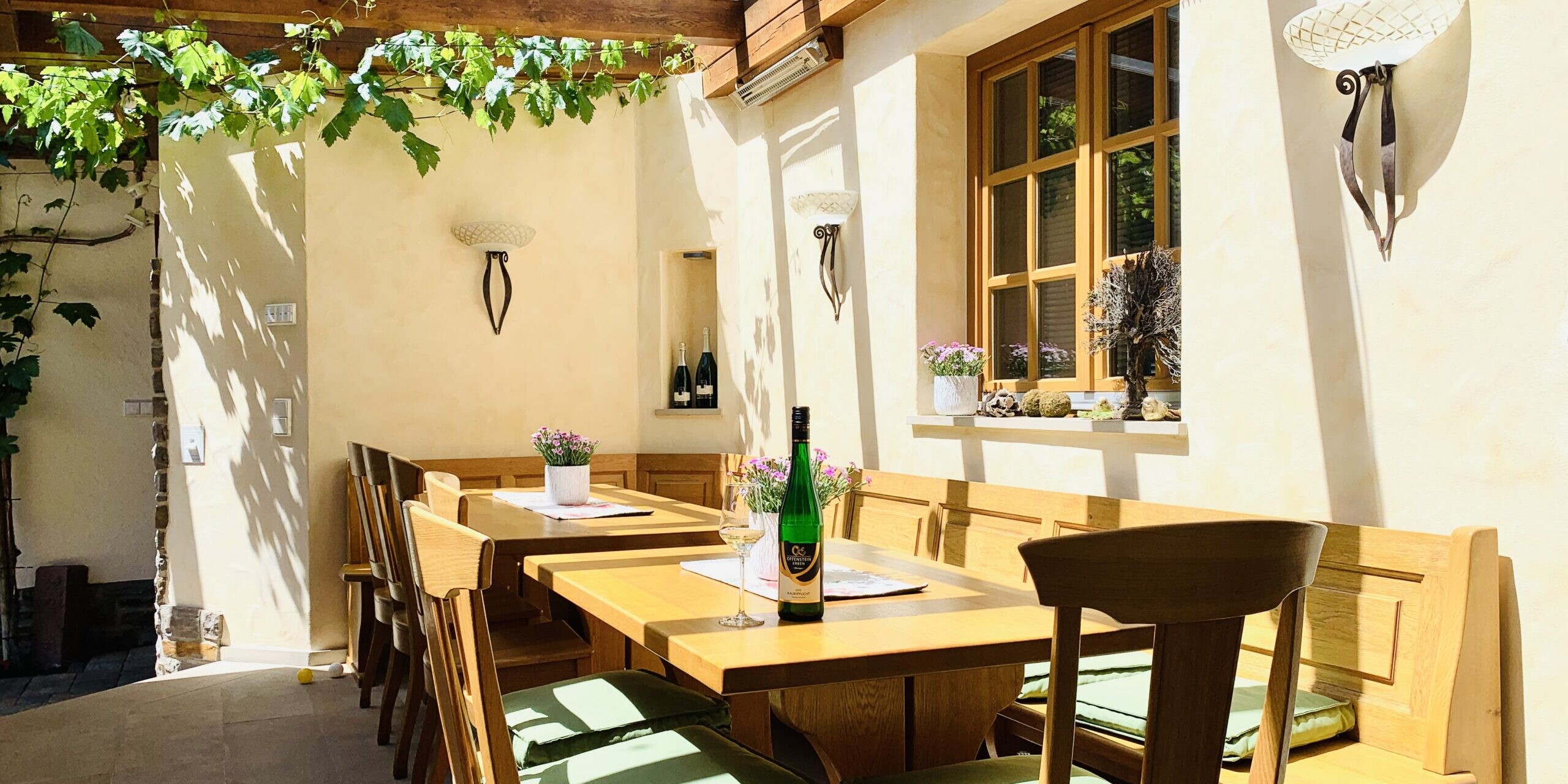 Helle Terrasse mit Holzstühlen und Pflanzen.
