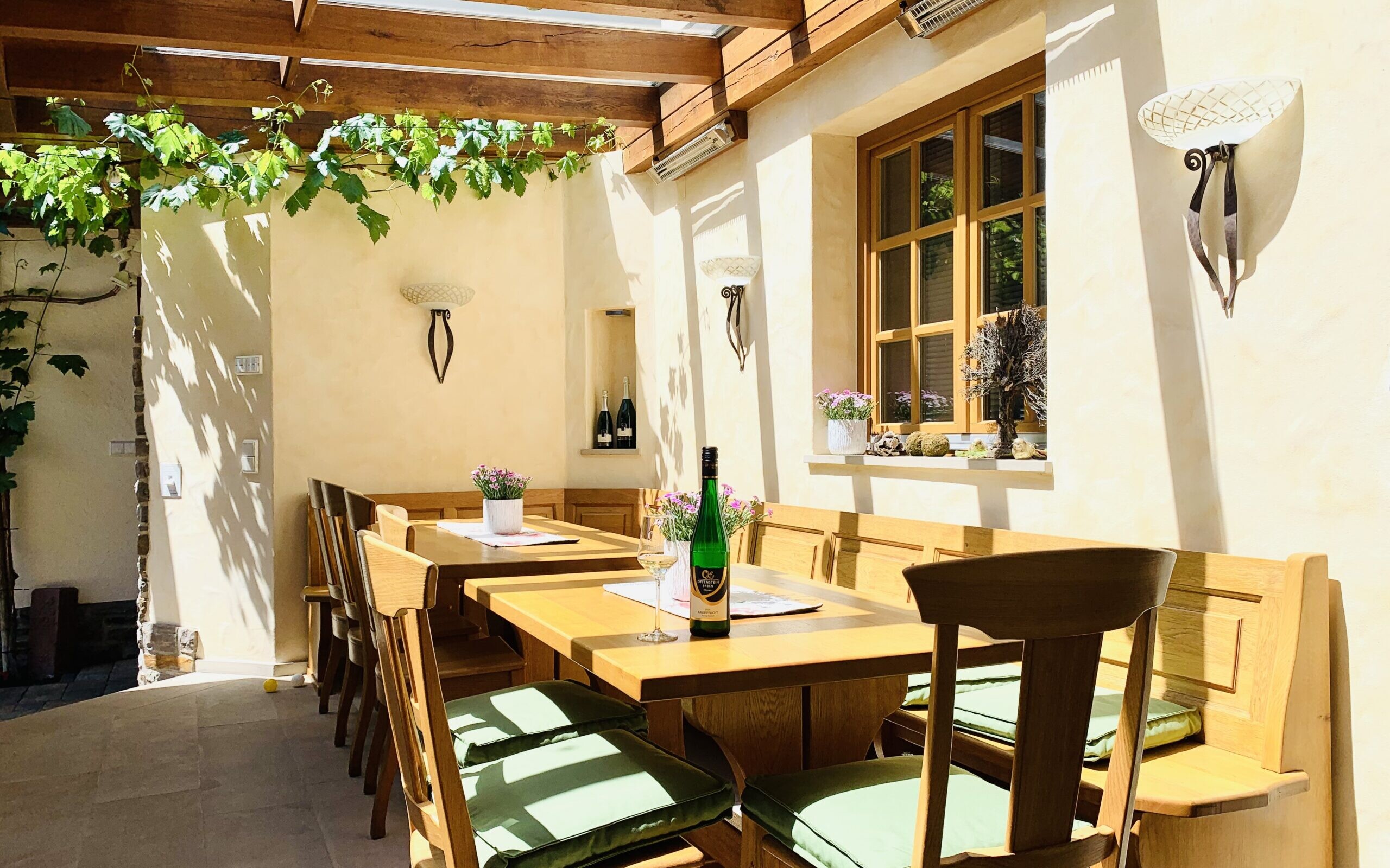 Helle Terrasse mit Holzstühlen und Pflanzen.