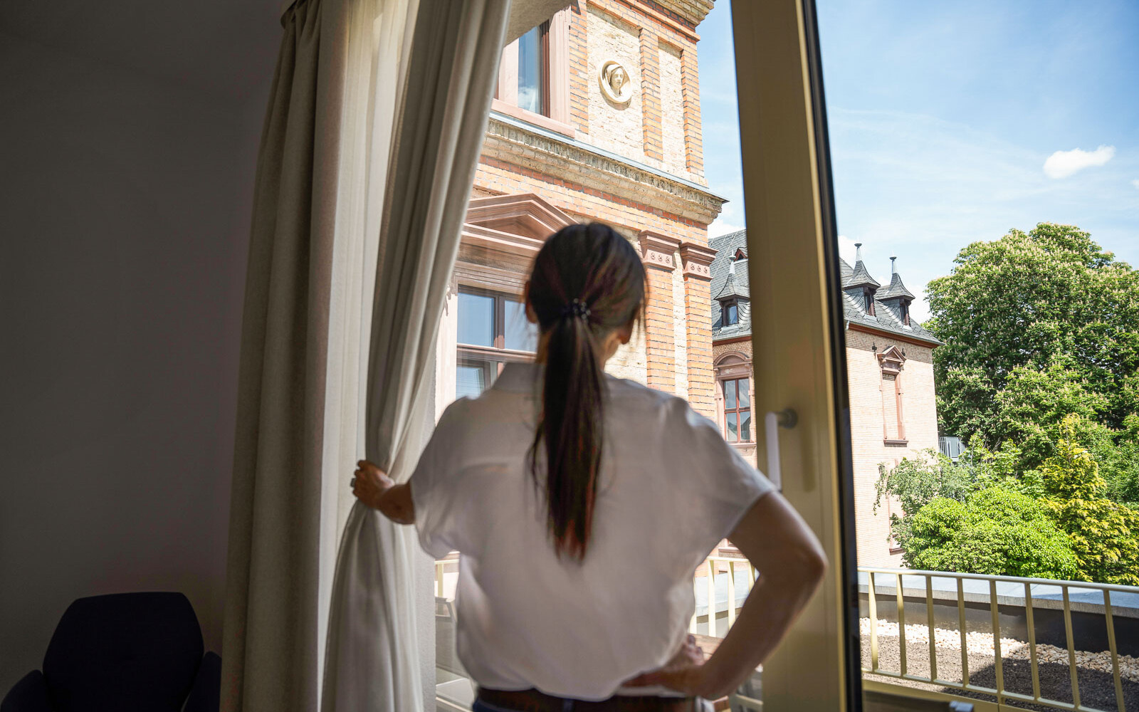 Frau schaut aus dem Fenster.