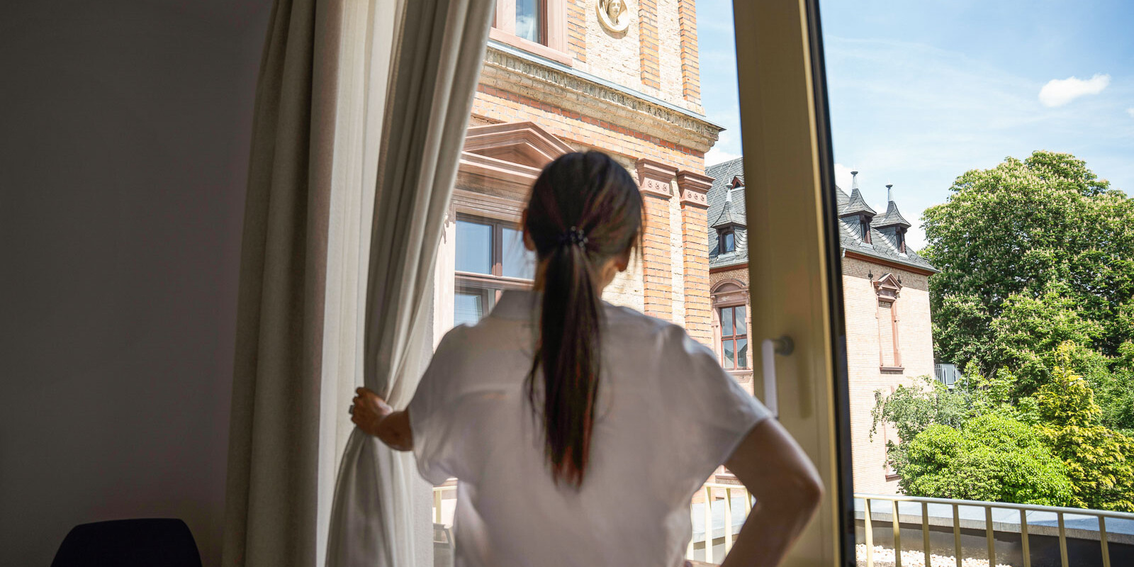 Frau schaut aus dem Fenster.