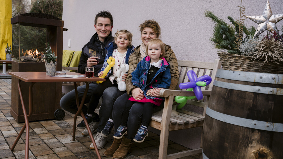 Familie sitzt zusammen im Freien.