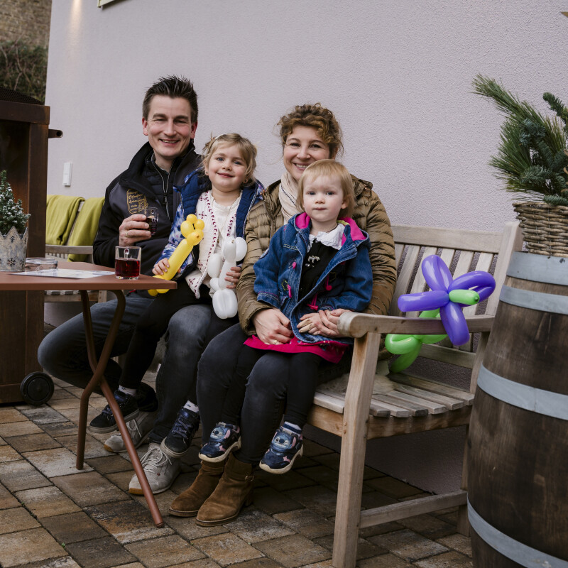 Familie sitzt zusammen im Freien.
