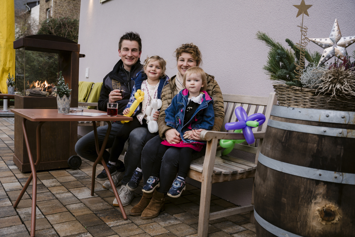 Familie sitzt zusammen im Freien.