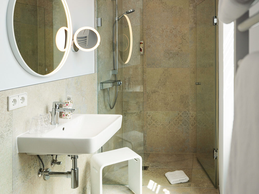 Modernes Badezimmer mit Dusche und Spiegel