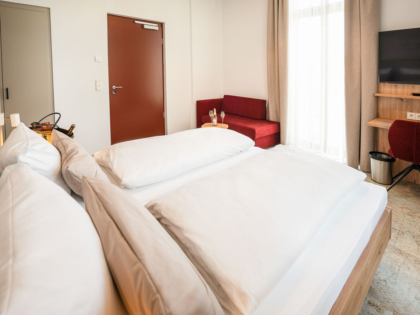 Helles Zimmer mit Doppelbett und Sofa.