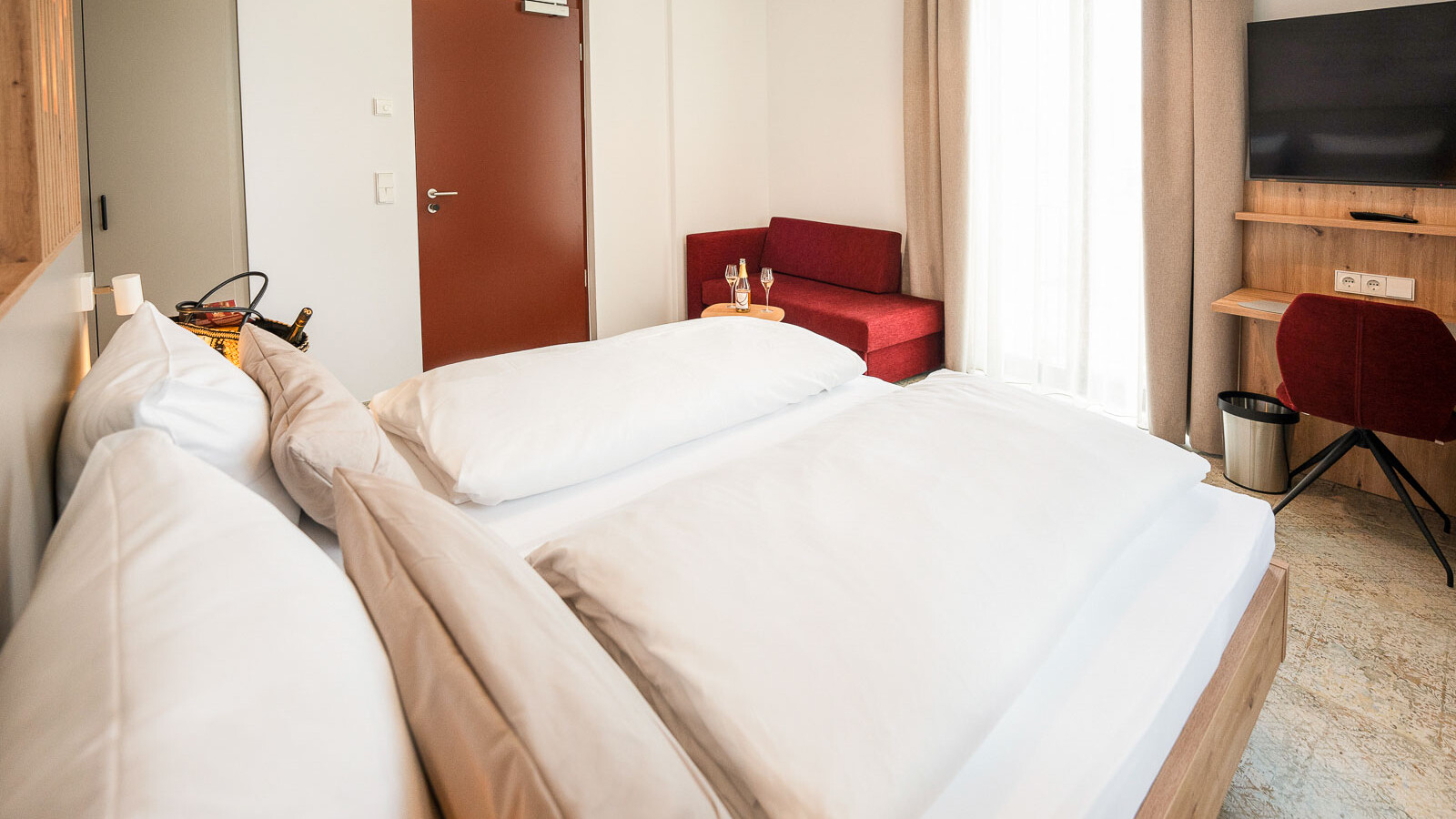 Helles Zimmer mit Doppelbett und Sofa.